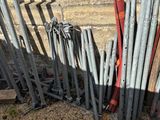 a pile of metal pipes next to a brick wall