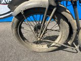 une vieille moto garée sur le bord de la route