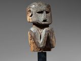a wooden sculpture of a man ' s head on a stand