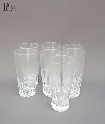 Quatre verres sont alignés sur une table devant un fond gris.