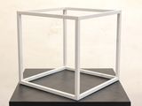 a white cube with a black base sitting on a table