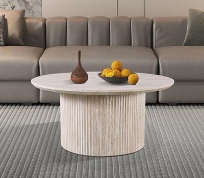 a table with a bowl of fruit on it in front of a couch