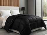 un lit noir et blanc dans une chambre dotée d'une grande fenêtre
