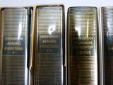 plusieurs vieux livres sont alignés sur une étagère