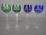 four wine glasses are lined up in a row on a table