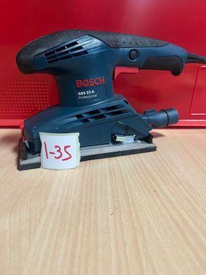 une ponceuse orbitale Bosch posée sur une table, avec une étiquette de prix dessus