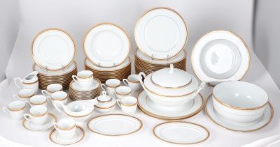 a lot of white and gold plates and bowls on a table