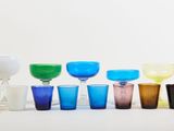 many different colored glasses lined up in a row