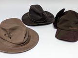 trois chapeaux sont alignés sur une surface blanche