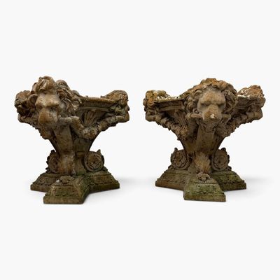 pair of carved stone sculptures of lions on pedestals