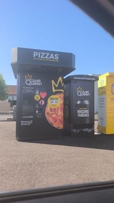 Trois distributeurs automatiques sont alignés sur un parking