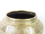 a gold vase with a design on it on a white surface