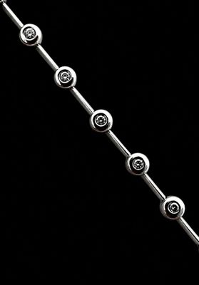 a close up of a silver bracelet on a black background