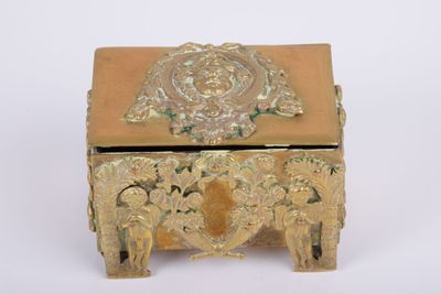 a gold box with a design on it on a white surface