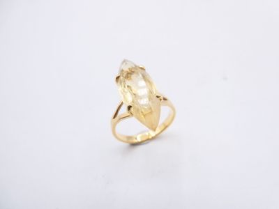 a close up of a gold ring with a yellow stone