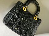 a close up of a small black purse on a white surface