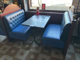a blue booth with a table and two blue chairs