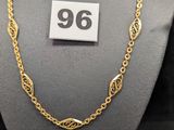 un collier en or exposé, muni d'une étiquette de prix