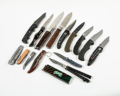 many different types of knives on a white surface