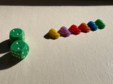 a row of dice and a row of colored dice on a table