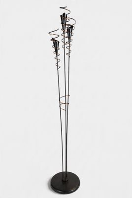 a black metal floor lamp with five candles on a black base