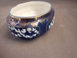 a blue bowl with a gold decoration on it