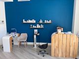 a photo of a salon with blue walls and a wooden counter
