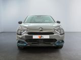 the front view of a silver citrole parked in a white room
