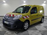 La petite camionnette jaune est garée dans une grande pièce au sol carrelé.