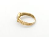 a close up of a gold and diamond ring on a white surface