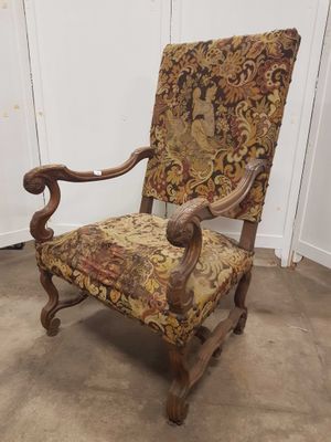 une vieille chaise dont l'assise est recouverte d'un tissu à motifs floraux, dans une pièce