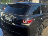 a black range rover parked in a lot with other cars