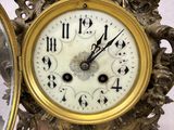 a gold clock sitting on top of a table next to a mirror