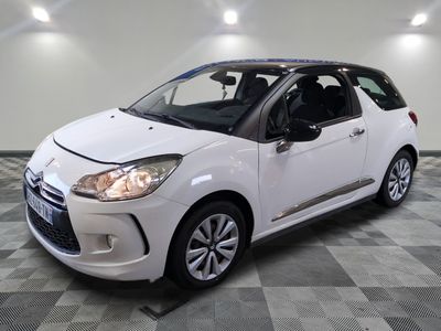 la petite voiture blanche est garée sur un sol en damier