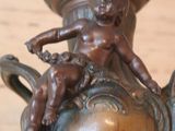 a bronze vase with a statue on top of it