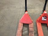 pair of red forklifts sitting on top of each other in a warehouse