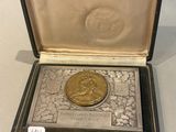 une pièce de monnaie ancienne en argent plaqué or, présentée dans un écrin