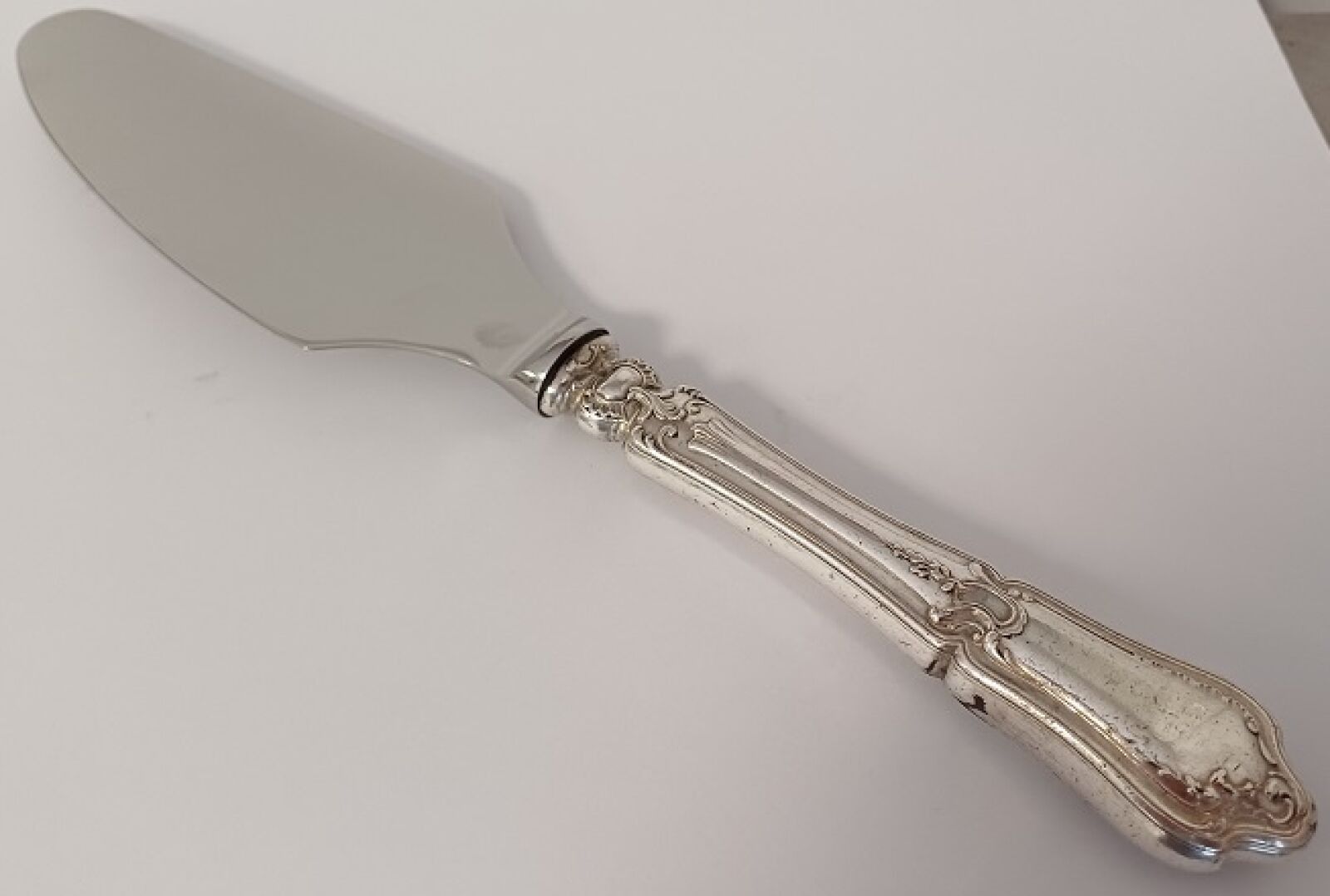 Pelle à tarte coupante manche en argent fourrré, poinçon Minerve 1°titre. Manche à décor de rocailles et de feuillage...