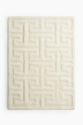 a white tile with a maze design on it