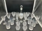 many glasses and a decanter sitting on a table