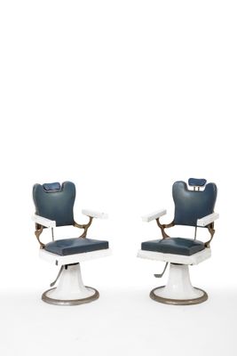 pair of blue and white barber chairs against a white background