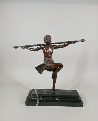 bronze statue of a woman holding a tennis racket on a marble base