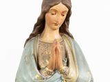 the statue of the virgin mary is holding her hands together