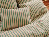 a bed with a green and white striped comforter on it