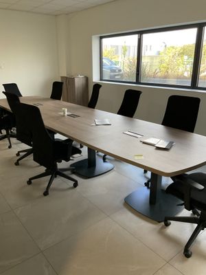 a long table with chairs and a laptop on it in a room