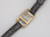 a close up of a watch on a white surface with a black strap