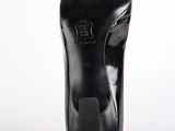 the bottom of a pair of black high heeled shoes on a white surface