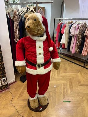 un ours en peluche déguisé en Père Noël dans un magasin de vêtements