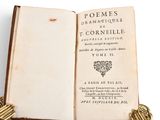 an open book sitting on top of a table next to a pair of gold rings