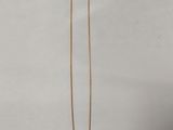 un collier en or dont l'extrémité est ornée d'une longue chaîne